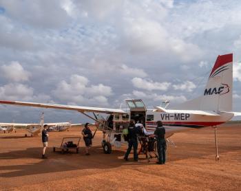 Aircraft and ambulance stretcher on tarmac