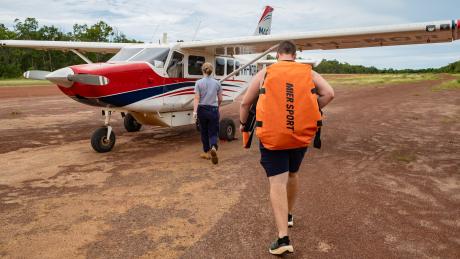 Physiotherapist and pilot walking toward aircraft