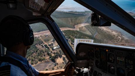 Pilot looking down at homeland airstrip on landing approach 