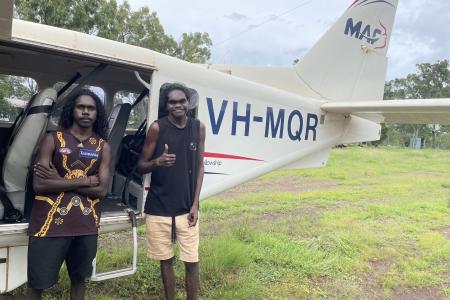 Laynhapuy Homelands School students Yalanba and Vernon with VH-MQR  in the Arnhem Land community of Gurrumuru.