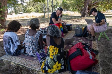 Nurses and Yolngu clients sitting under a tree