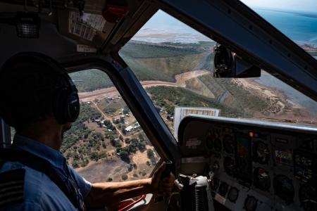 Pilot looking down at homeland airstrip on landing approach 