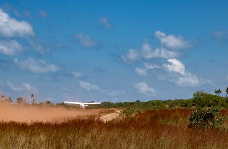 Aircraft taking off from dirt strip