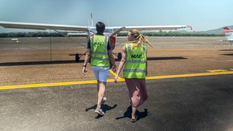 Young couple walking to plane on tarmac