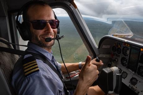 In plane cockpit pilot smiling thumbs-up at camera