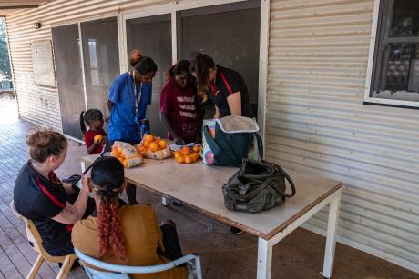 Agency staff and clients gathered around table on verandah
