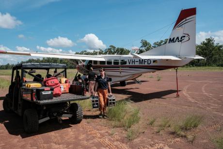 unloading aircraft at dirt airstrip