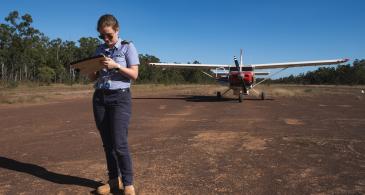 pilot with clipboard on airstrip